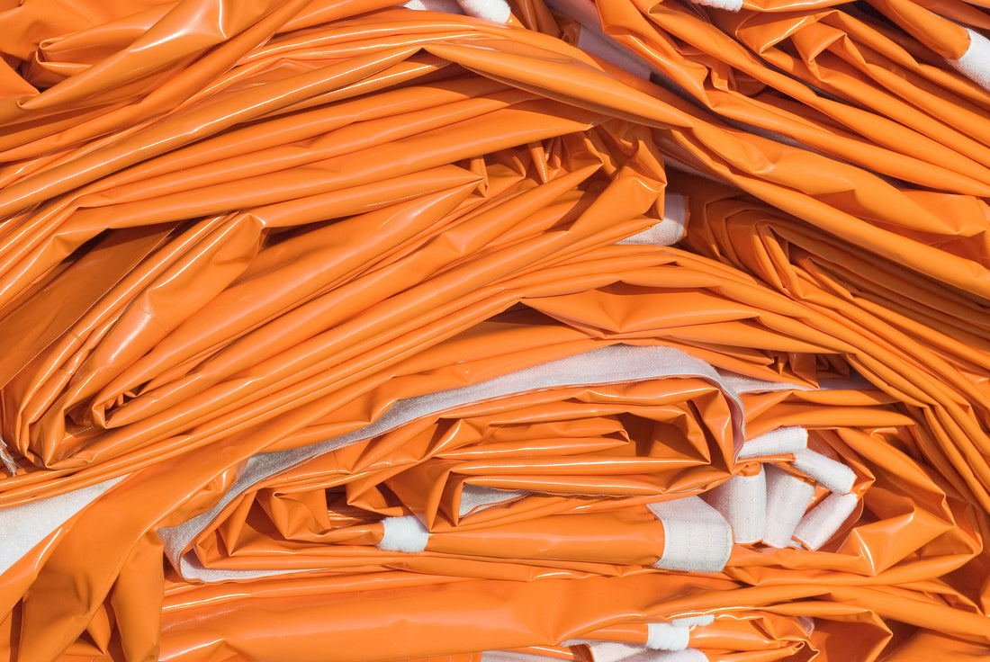 closeup image of stacked Orange tarps-Supreme Tarps