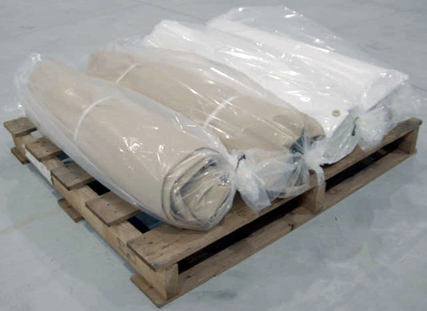 Image of horizontally stacked Beige & White 40x40 Tarps on wooden skid-Supreme Tarps